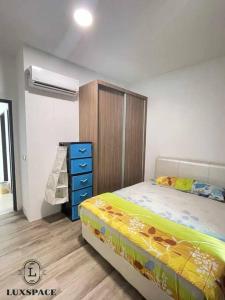 a bedroom with a bed and a dresser in it at Kuching City 3rd Mile Batu Kawa Cozy Apartment in Kuching