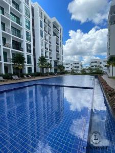 a large swimming pool in front of some buildings at Kuching City 3rd Mile Batu Kawa Cozy Apartment in Kuching