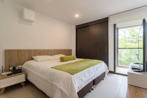 1 dormitorio con 1 cama grande y TV en Hermoso loft en Llanogrande, en Rionegro