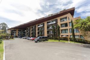 a hotel with cars parked in a parking lot at Hermoso loft en Llanogrande in Rionegro