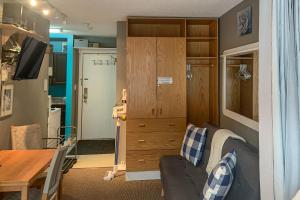 sala de estar con sofá y armario de madera en The Lepard's Den - Whitefoot Lodge 206, en Big White