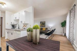 a kitchen and living room with a table with plants on it at COZY 1BR Top Floor with Balcony Newly Renovated in Fort McMurray