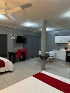 een kamer met een bed en een keuken met rode stoelen bij Preciados Loft Cold AC best WIFI in Tequila