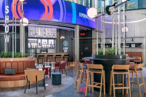 a restaurant with chairs and tables and a bar at STAGES HOTEL Prague, a Tribute Portfolio Hotel in Prague