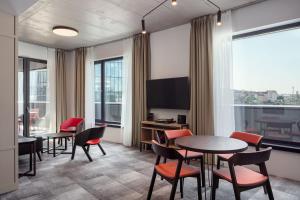 a room with tables and chairs and a tv at STAGES HOTEL Prague, a Tribute Portfolio Hotel in Prague