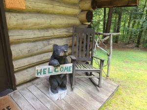 una estatua de un oso sentado en una mecedora en Cabin 1426, en Northville