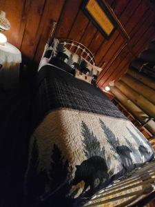 Una cama en una habitación con una manta. en Cabin 1426, en Northville