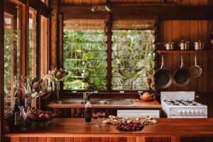 cocina con fregadero y fogones horno superior en The Canopy Rainforest Treehouses & Wildlife Sanctuary, en Tarzali