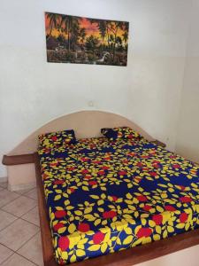 uma cama com um edredão colorido num quarto em Campement Nyabinghi em Abémé