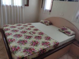 a bed with a floral comforter and two pillows on it at Campement Nyabinghi in Abene