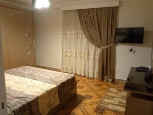 1 dormitorio con 1 cama y TV en شقة المهندسين, en El Cairo