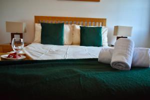 a bed with green and white sheets and pillows at Business Stays in Reading with FREE Parking in Reading