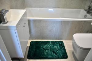 a bathroom with a green bath mat on the floor at Business Stays in Reading with FREE Parking in Reading