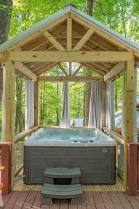 a large hot tub in a pavillion with a wooden roof at Stefan Cabin Nature-nested Tiny Home Hot Tub in Chattanooga