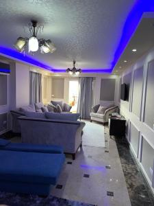 sala de estar con luces azules en el techo en شقة المهندسين, en El Cairo