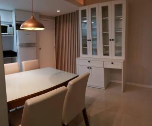- une cuisine avec une table, des armoires et des chaises blanches dans l'établissement Apartamento na Praia Brava - Florianópolis, à Florianópolis