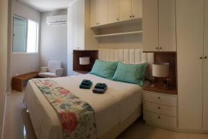 - une chambre avec un grand lit et 2 serviettes dans l'établissement Apartamento na Praia Brava - Florianópolis, à Florianópolis