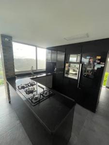 uma cozinha com um fogão e uma bancada em Casa combia de lujo em Pereira