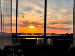 um pôr-do-sol visto através de uma janela com um sofá em Cozy and nice stay with sunset view! em Mooroolbark