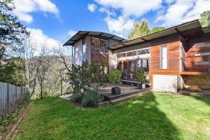 a house with a large window and a yard at Mountain Nest - LEURA in Leura