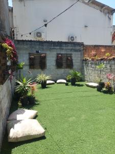 un jardín con plantas y rocas en la hierba en Hospedagem Casa Girassol en Praia Grande