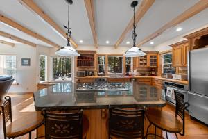 a kitchen with a large island with a counter top at Fox Crossing at Tahoe Donner by Tahoe Getaways - 3BR Vacation Rental w Forested Views & HOA Amenities! in Truckee
