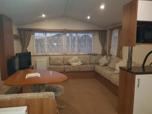 a living room with a couch and a table at 2013 Willerby Sunset Static Caravan Holiday Home in Clacton-on-Sea