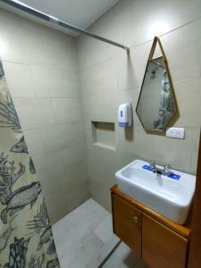 y baño con lavabo y espejo. en Elegante Suite ecualodge2, en Cuenca