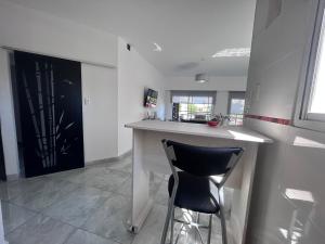 a kitchen with a bar with a black chair at Apart Luro I in Santa Rosa