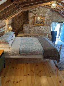 a bedroom with a large bed in a stone wall at Morialta Barns in Norton Summit