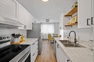 uma cozinha branca com armários brancos e um lavatório em Spacious 2BR Top Floor with Balcony Free WiFi em Fort McMurray