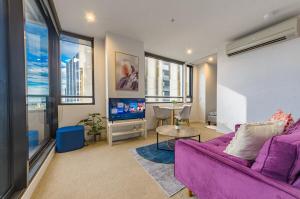 a living room with a purple couch and a tv at High Level On 42th Floor 2br 1ba Balcony in Melbourne