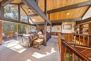 una gran sala de estar con techos con paneles de madera y chimenea. en Nightingale Retreat - 3BR, Close to Tahoe City, Walk to Bike Path, Private Beach Access en Tahoe City