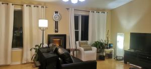 伊魁特的住宿－Grant Arctic Escape，客厅配有沙发和墙上的时钟
