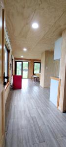 Habitación grande con suelo de madera y silla roja. en Casa Rayen Puerto Varas, en Puerto Varas