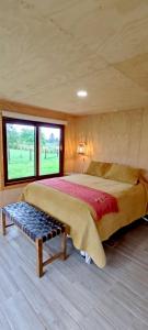 Un dormitorio con una cama grande y un banco. en Casa Rayen Puerto Varas, en Puerto Varas