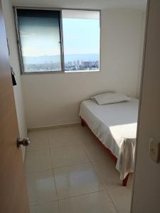 a small bedroom with a bed and a window at Alex & Kamilo in Bucaramanga