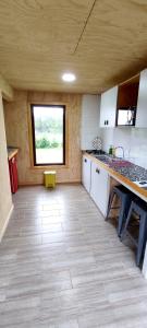a large kitchen with white cabinets and a window at Casa Rayen Puerto Varas in Puerto Varas
