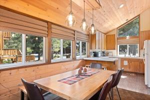 cocina y comedor con mesa de madera y sillas en Rustic Retreat in Tahoe Donner- Contemporary Cabin, Forest Views, Pet-Friendly, Amenities, en Truckee