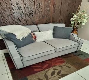a grey couch with two pillows on it at Green Castle Apartment in Tampa Near Airport and Busch Gardens in Tampa