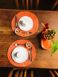dwie talerze jedzenia na drewnianym stole w obiekcie Ouro Preto Homely Hostel w mieście Ouro Preto