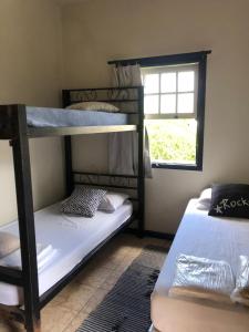 2 łóżka piętrowe w pokoju z oknem w obiekcie Ouro Preto Hostel w mieście Ouro Preto