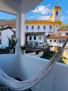 a hammock on a balcony with a view of a building at Ouro Preto Hostel in Ouro Preto