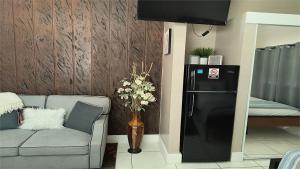 a living room with a couch and a refrigerator at Green Castle Apartment in Tampa Near Airport and Busch Gardens in Tampa