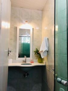 a bathroom with a sink and a mirror and a shower at Ouro Preto Hostel in Ouro Preto