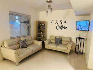 sala de estar con 2 sofás y TV en Casa Castaño Cd Jrz, en Ciudad Juárez