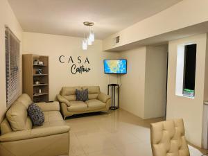 a living room with two couches and a flat screen tv at Casa Castaño Cd Jrz in Ciudad Juárez