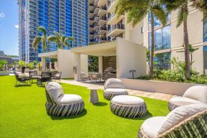 un jardin avec des chaises et des tables ainsi qu'un bâtiment dans l'établissement Sky Ala Moana 2908 condo, à Honolulu