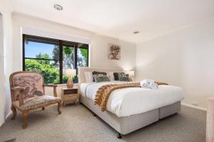 ein Schlafzimmer mit einem Bett, einem Stuhl und einem Fenster in der Unterkunft Sunset Lodge - Breathtaking Views in Orange