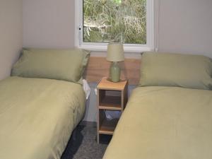 2 Betten in einem Zimmer mit Fenster in der Unterkunft The Finch in Dyke